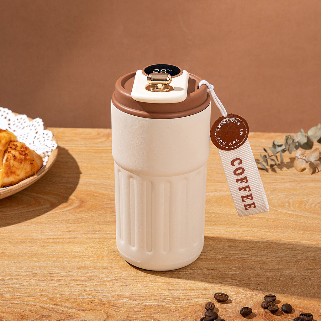 White and brown insulated coffee tumbler with a 'Coffee' tag on a wooden surface.