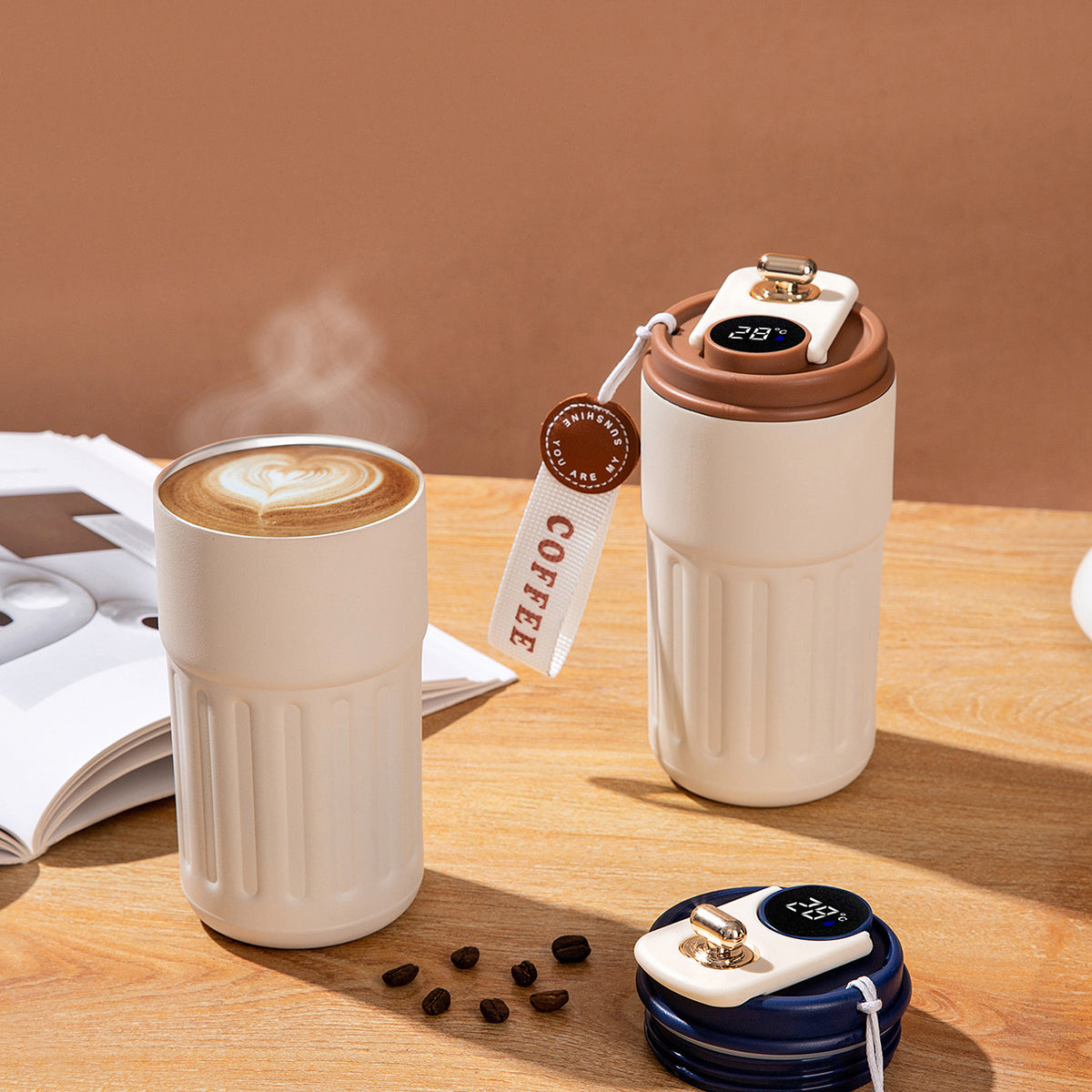 Two ceramic travel coffee cups with digital temperature displays on a wooden surface.