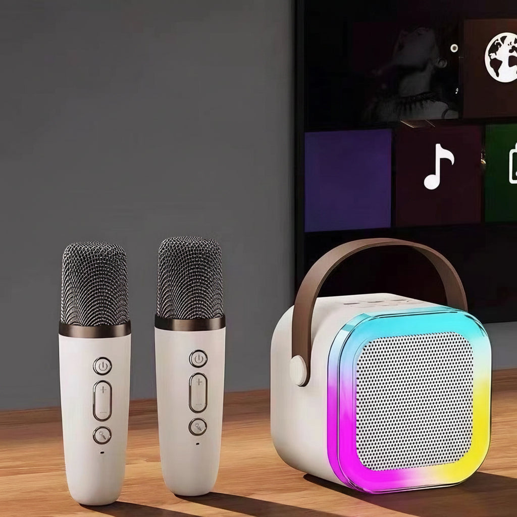 Two microphones and a portable speaker on a wooden surface.