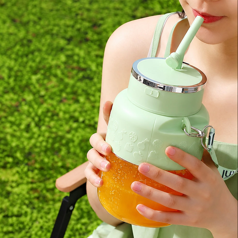Person holding a green juice cup with a straw, featuring text about the product on a grassy background.
